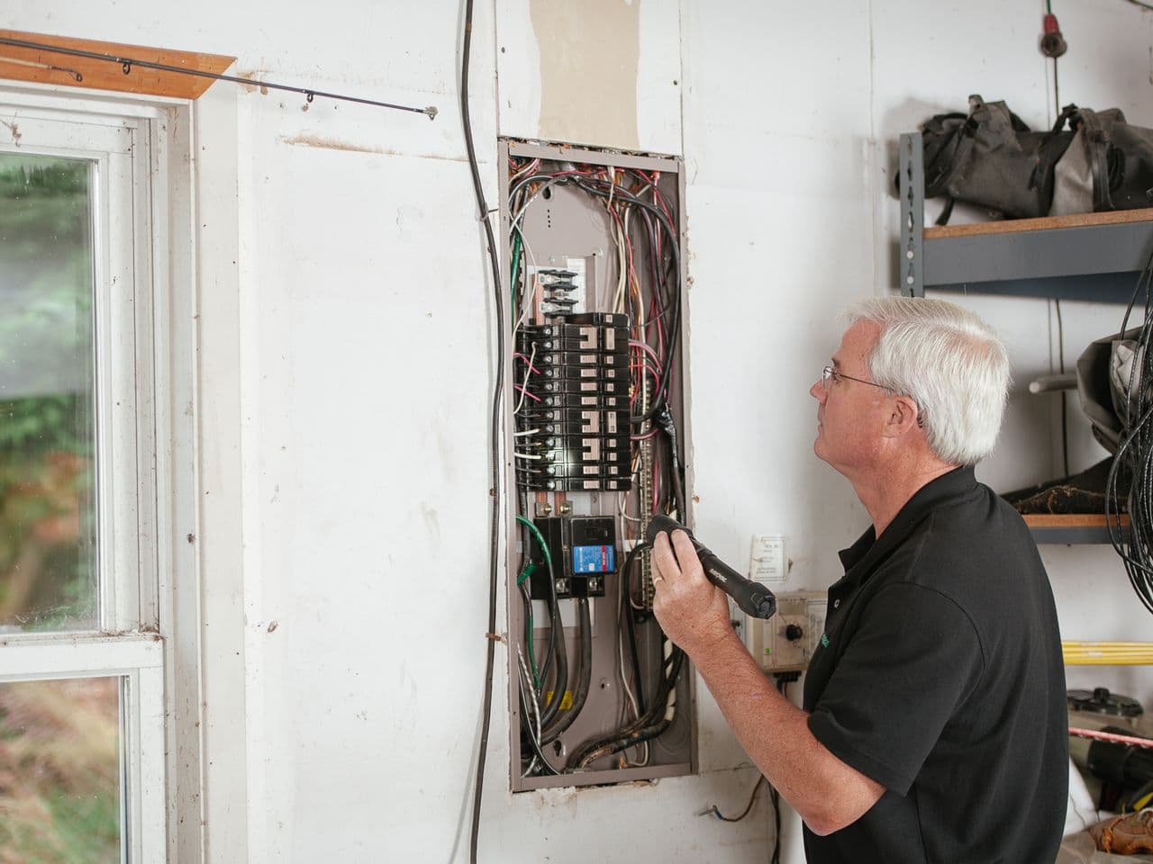 Residential fuse box getting a careful once-over from an electrician