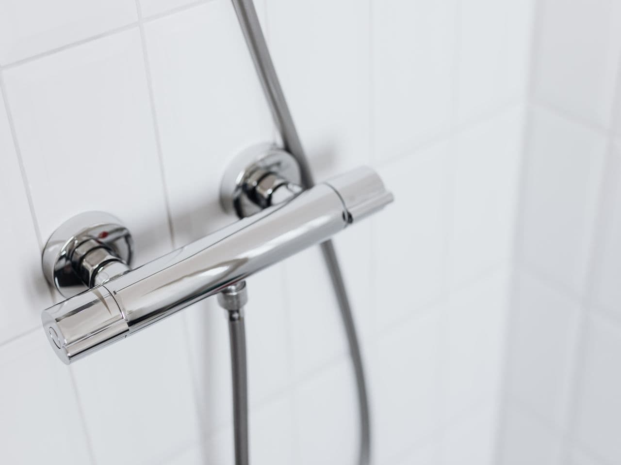 Polished chrome shower head installed against fresh bathroom tile